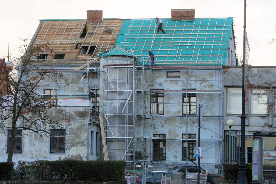 Ant istorinio Klaipėdos senamiesčio pastato stogo – darbininkai be šalmų