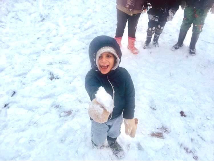 Žemę nuklojęs sniegas migrantų stovykloje pasėjo džiaugsmą: susižavėjimo neslėpė ne tik mažieji